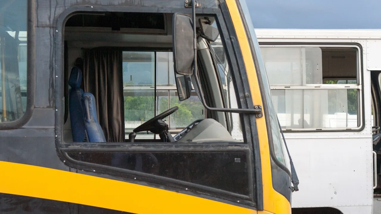 Ônibus de transporte escolar parado em via pública.