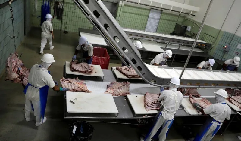 Trabalhadores em linha de produção industrial no Brasil.