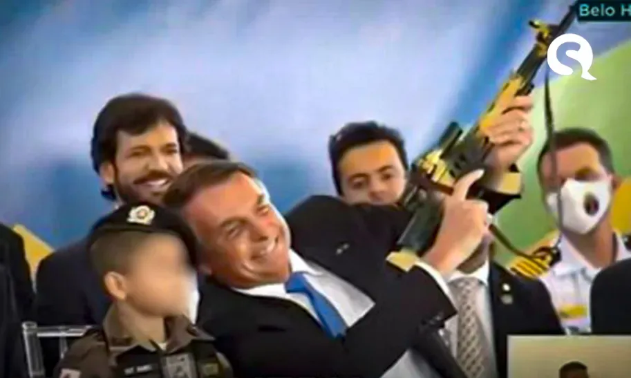 Em cerimônia, Bolsonaro segura fuzil de brinquedo ao lado de criança vestida de militar